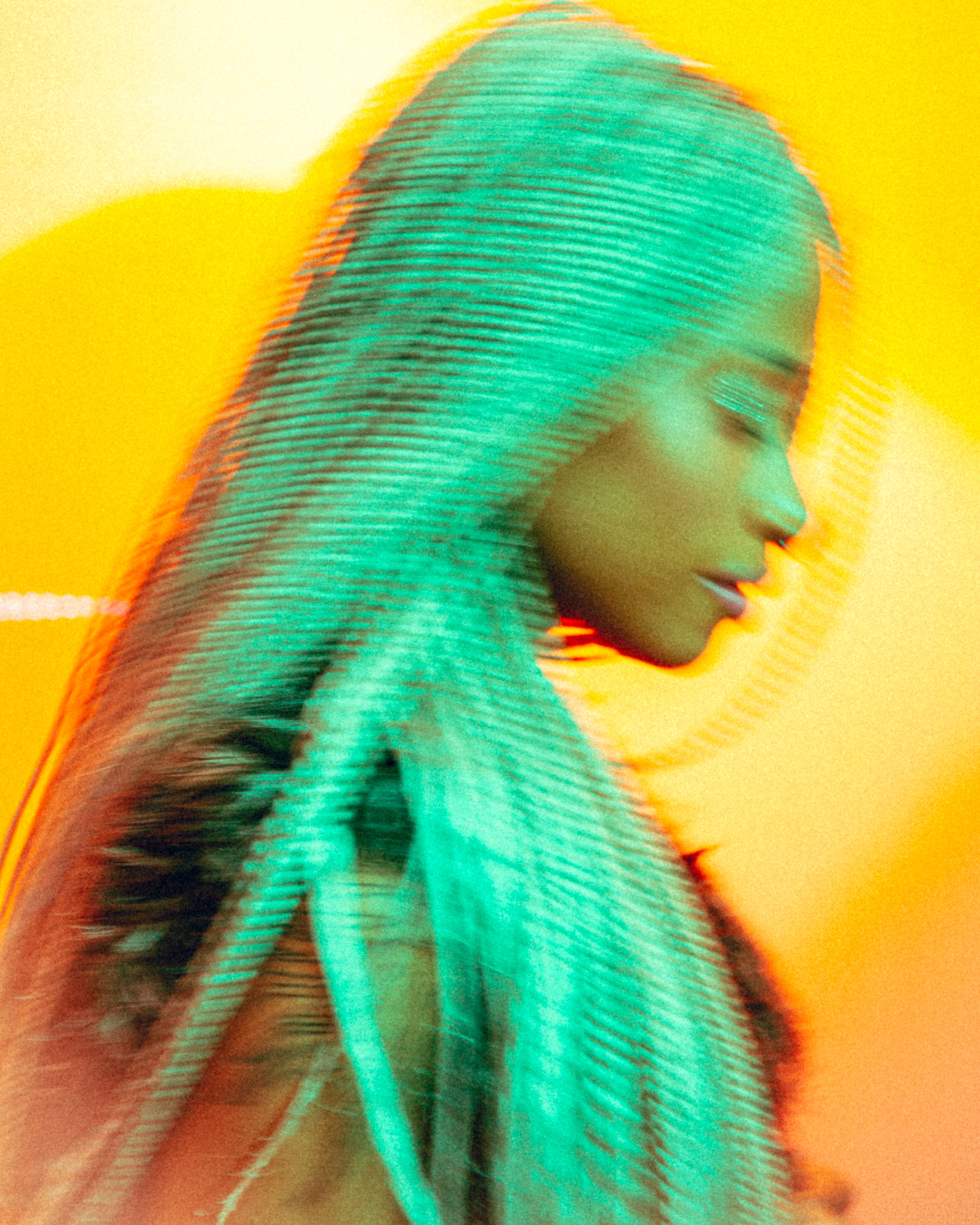 Artistic portrait of a woman with braids in motion, vibrant and dynamic with yellow and green tones.