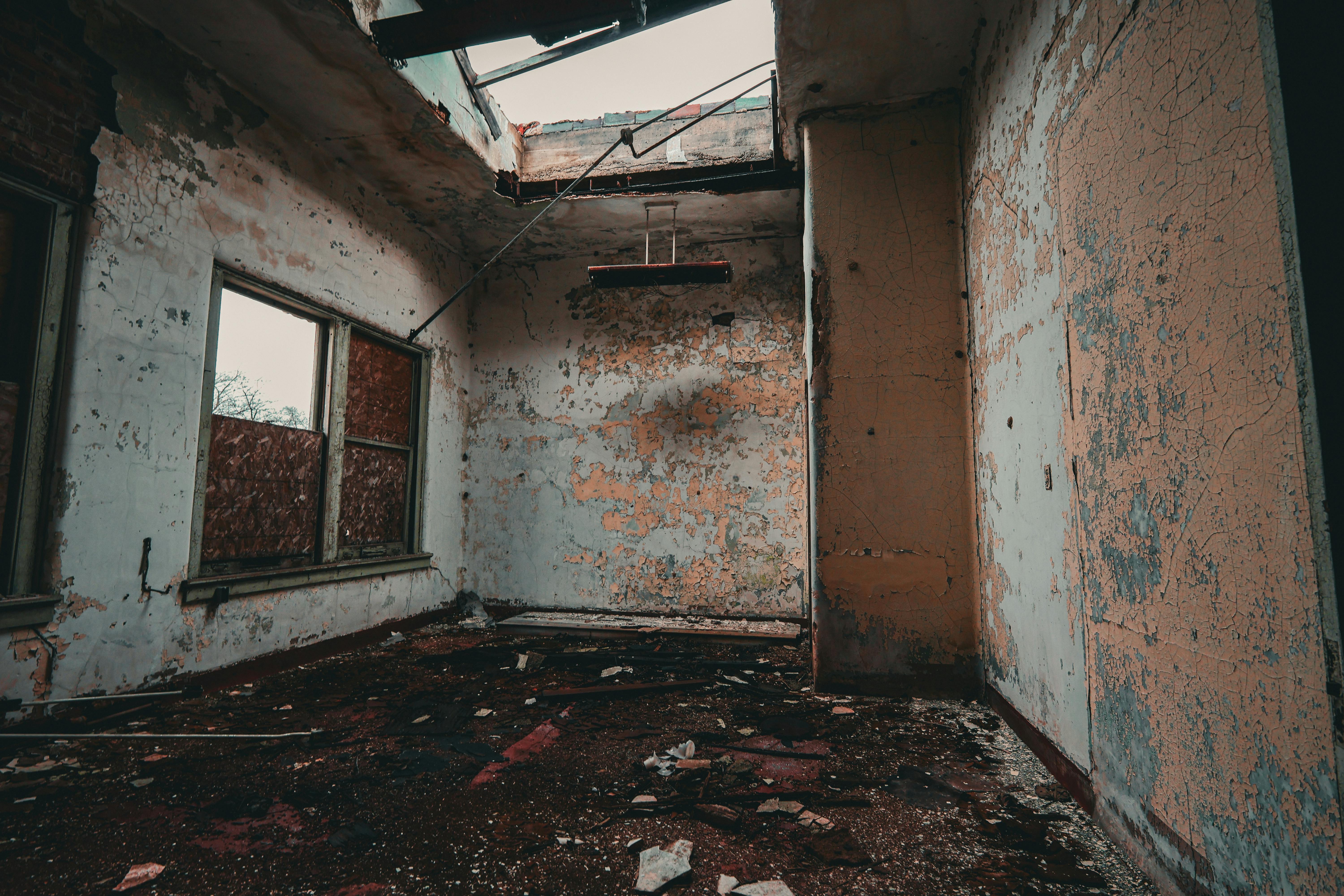 Gratuit Interiorul unei clădiri abandonate prezintă pereți exfoliați și resturi, creând o senzație de degradare. Fotografie de stoc