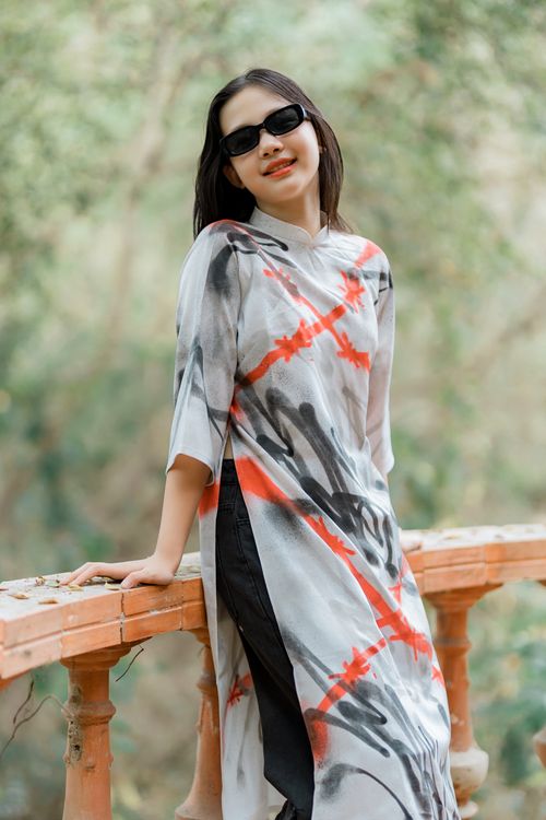 Free Chic woman in sunglasses wearing a modern artistic dress, outdoors in nature. Stock Photo