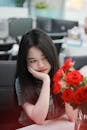Pensive Woman with Red Roses in Office Setting