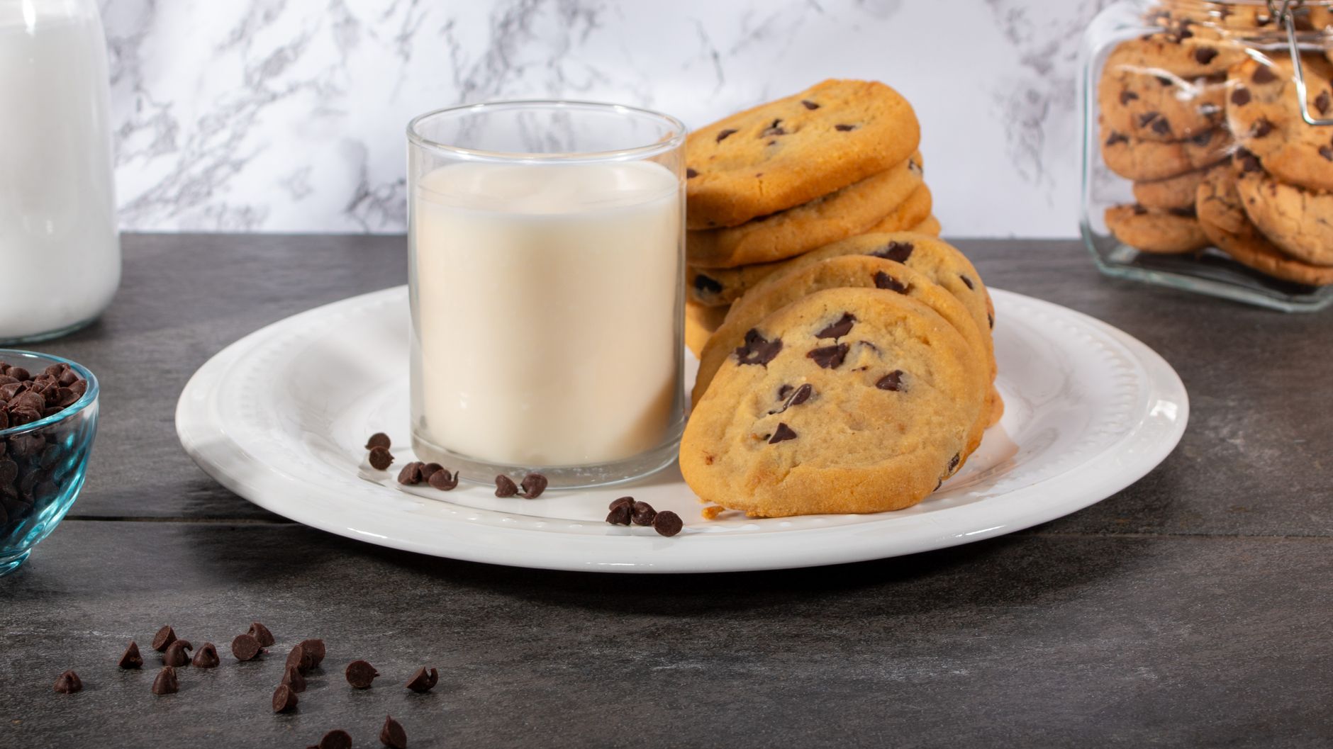 Hands scooping almond flour chocolate chip cookie dough onto baking sheet