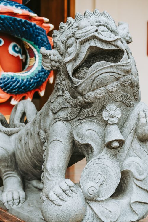 Free Intricate stone guardian lion statue at a temple in Surabaya, showcasing artistic craftsmanship. Stock Photo