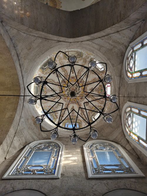 Free Chandelier and ornate dome ceiling in a historic İstanbul mosque with decorated windows. Stock Photo