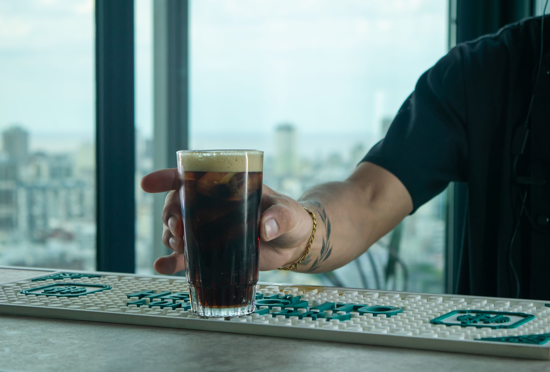 Bartender Serving Cold Brew Coffee with City View · Free Stock Photo