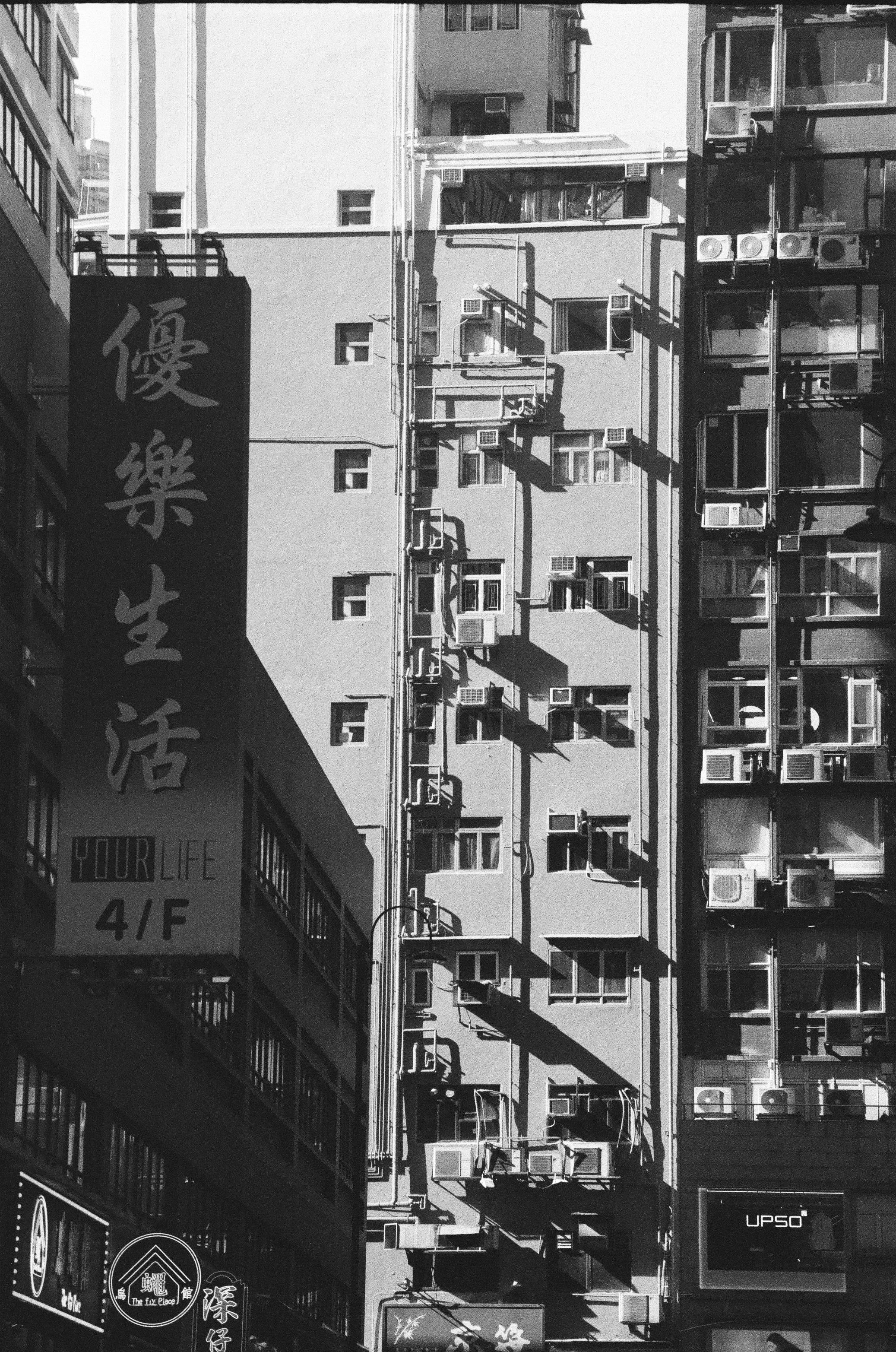 Free Black and white photo of urban high-rise buildings with air conditioners in an Asian city. Stock Photo