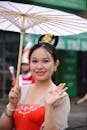 Traditional Asian Attire with Parasol in Festive Setting