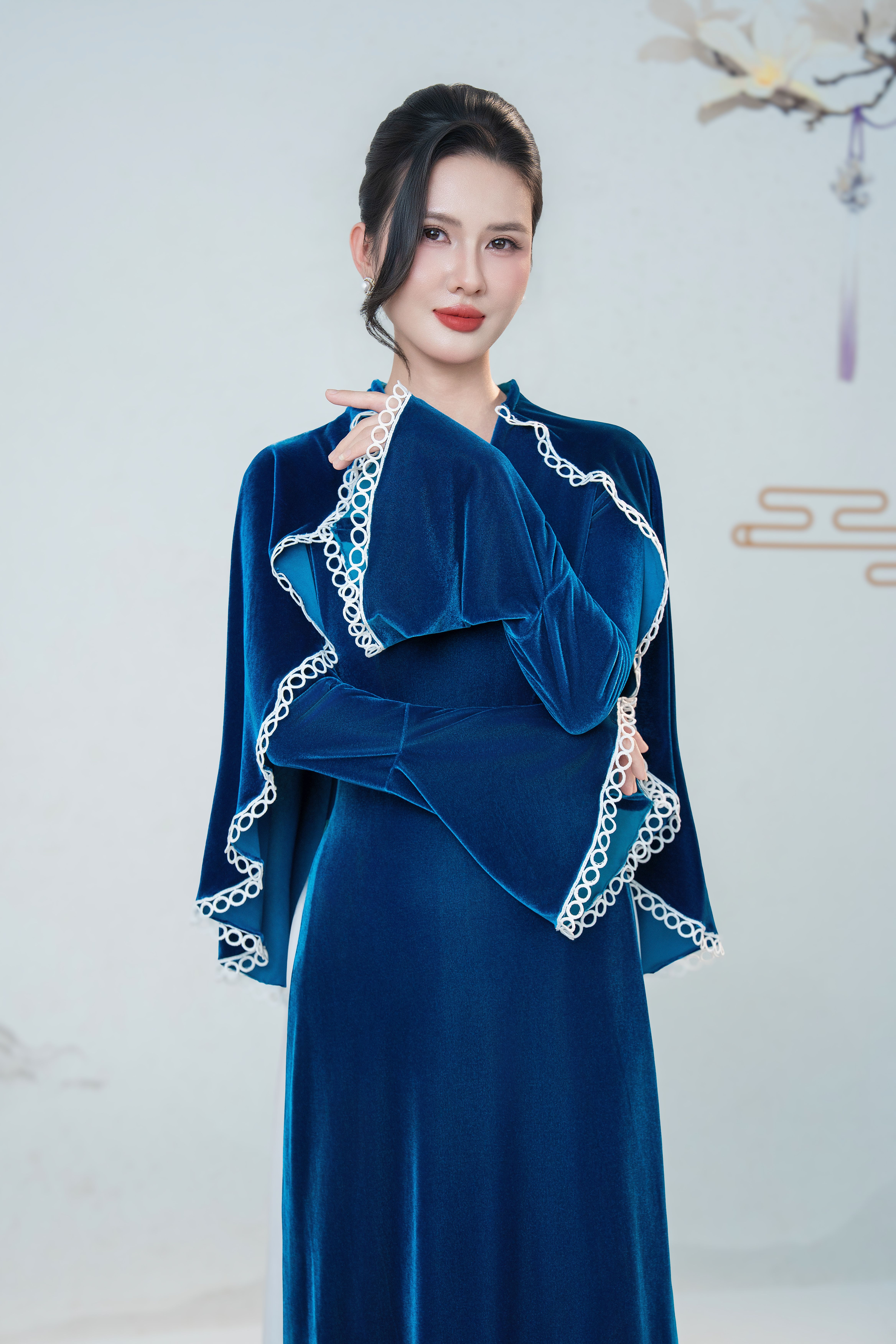 Portrait of a woman in elegant blue velvet traditional attire indoors.