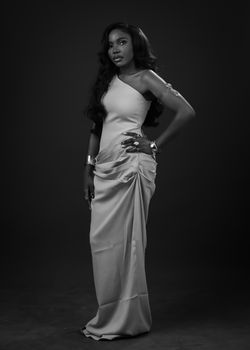 Stylish black and white portrait of a woman in a classy gown, exuding elegance.