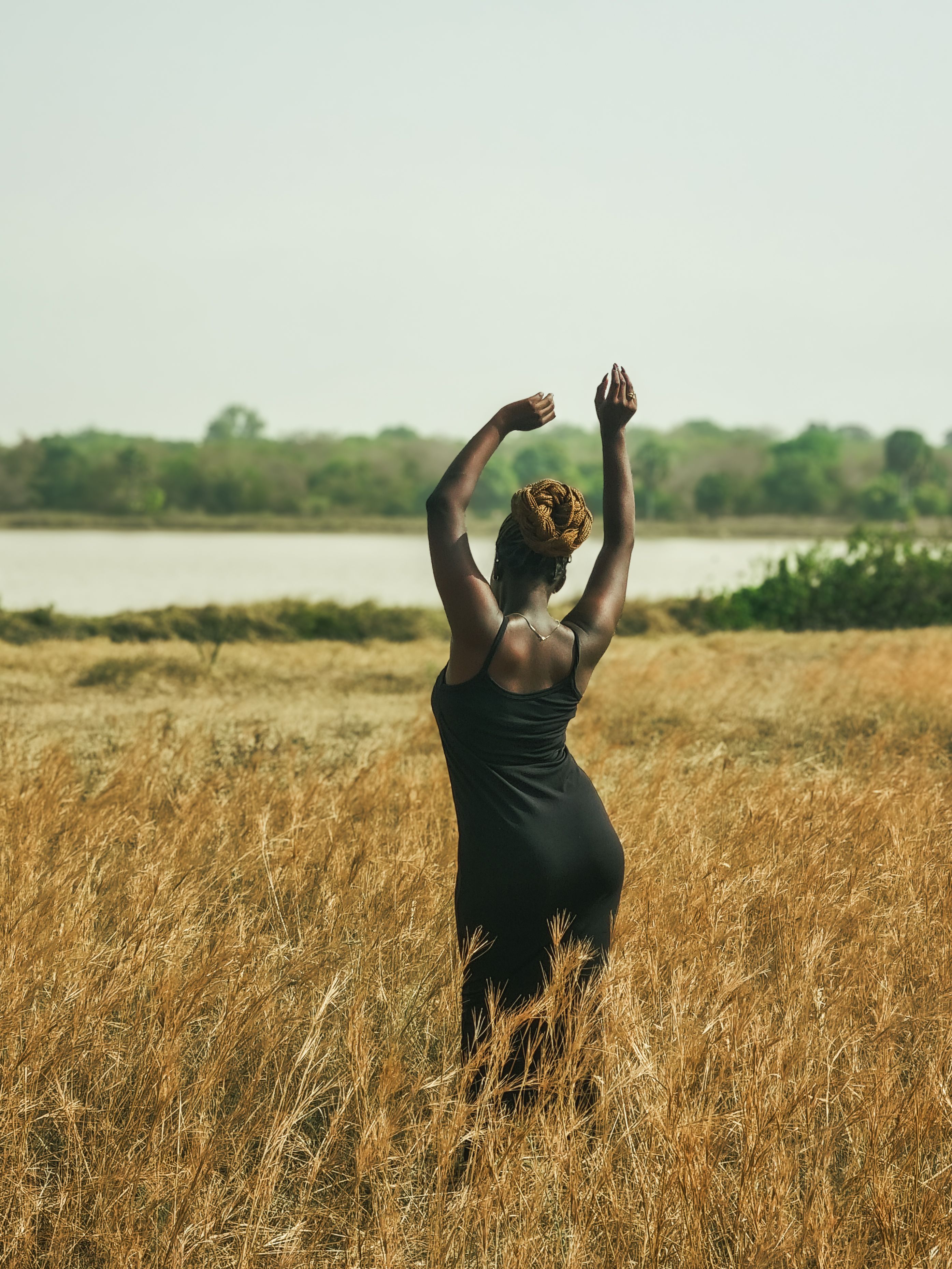 Woman Standing in Field by a River · Free Stock Photo