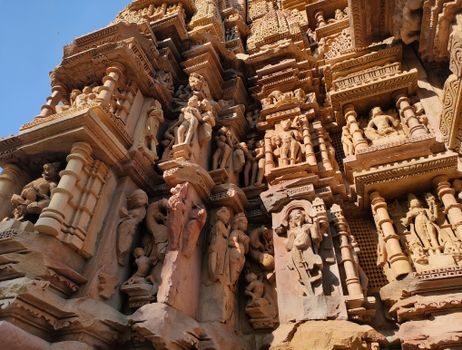 Detailed stone carvings on a temple facade in Khajuraho, India showcasing ancient Indian artistry.