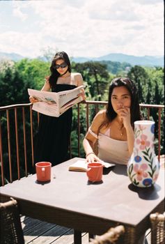 Two women enjoying a sunny day on a terrace in Biarritz, France.