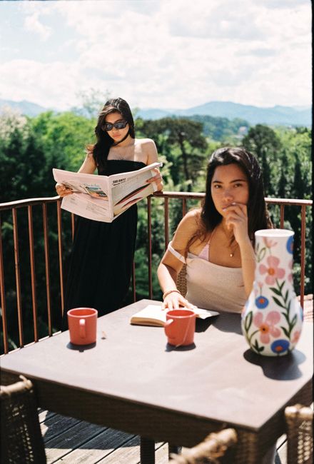Two women enjoying a sunny day on a terrace in Biarritz, France.