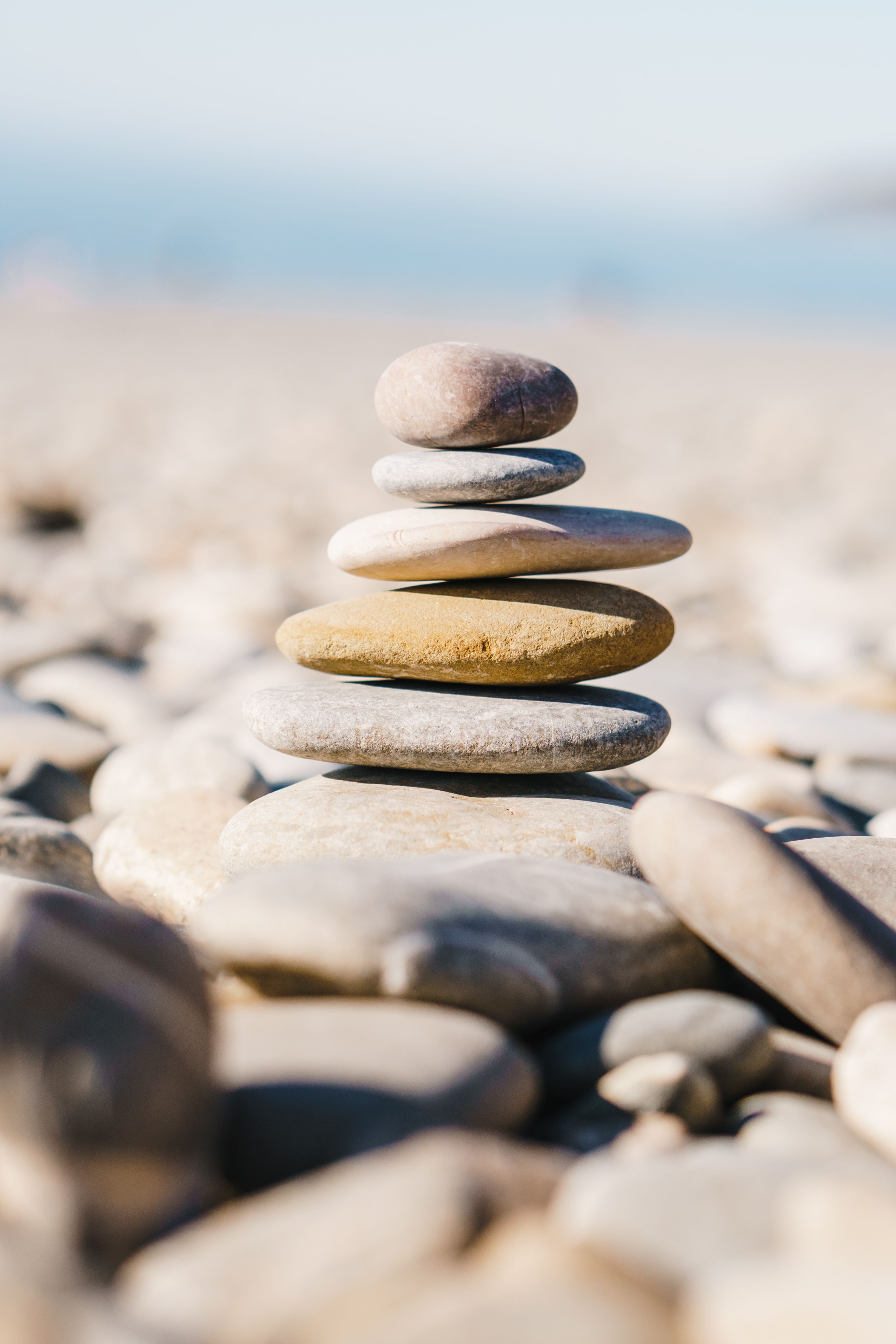 Serene Stack of Zen Stones on a Sunlit Beach · Free Stock Photo