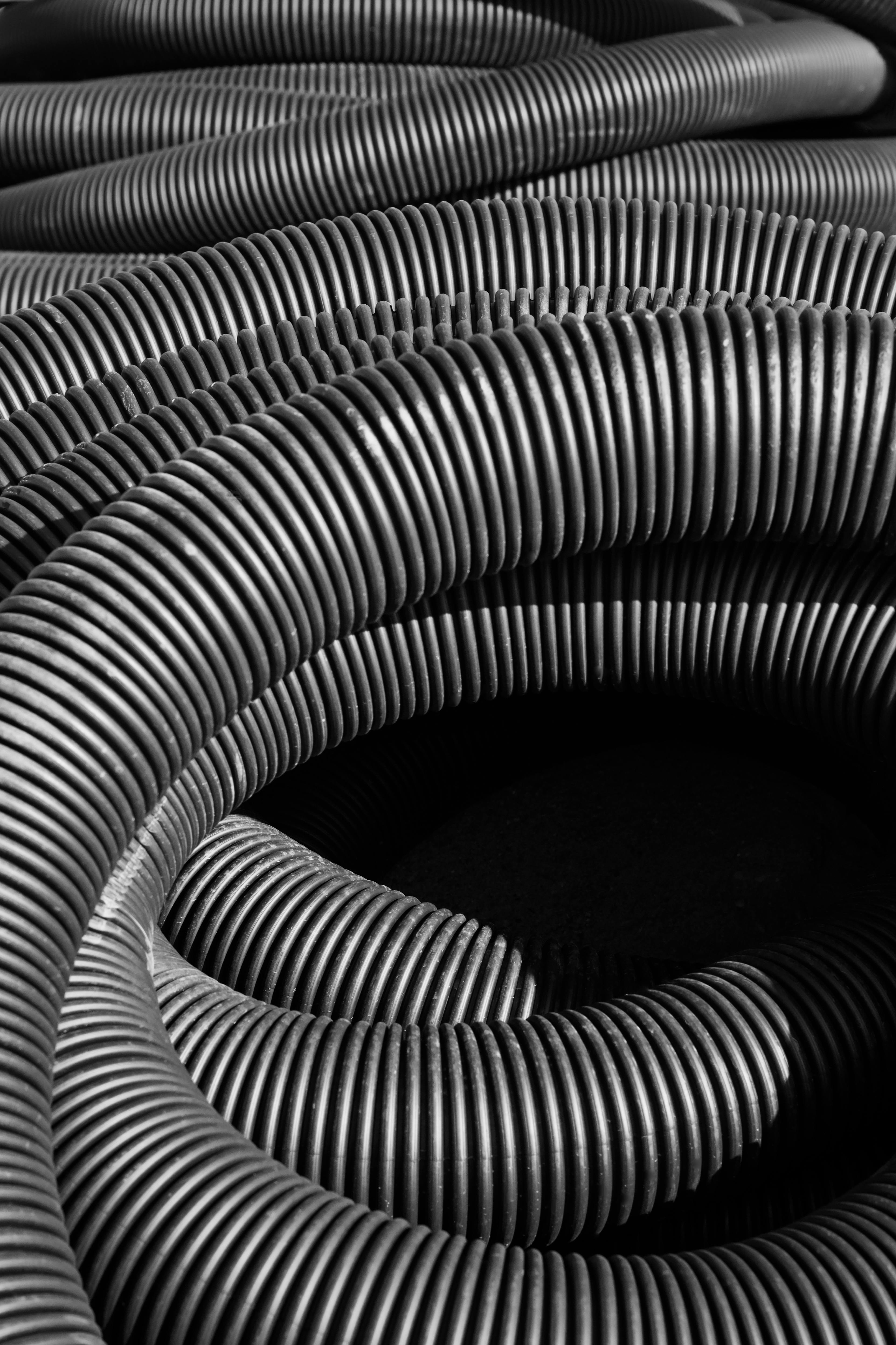 ฟรี ภาพขาวดำที่เน้นพื้นผิวของท่อลูกฟูกอุตสาหกรรมที่ม้วนเป็นเกลียว คลังภาพถ่าย