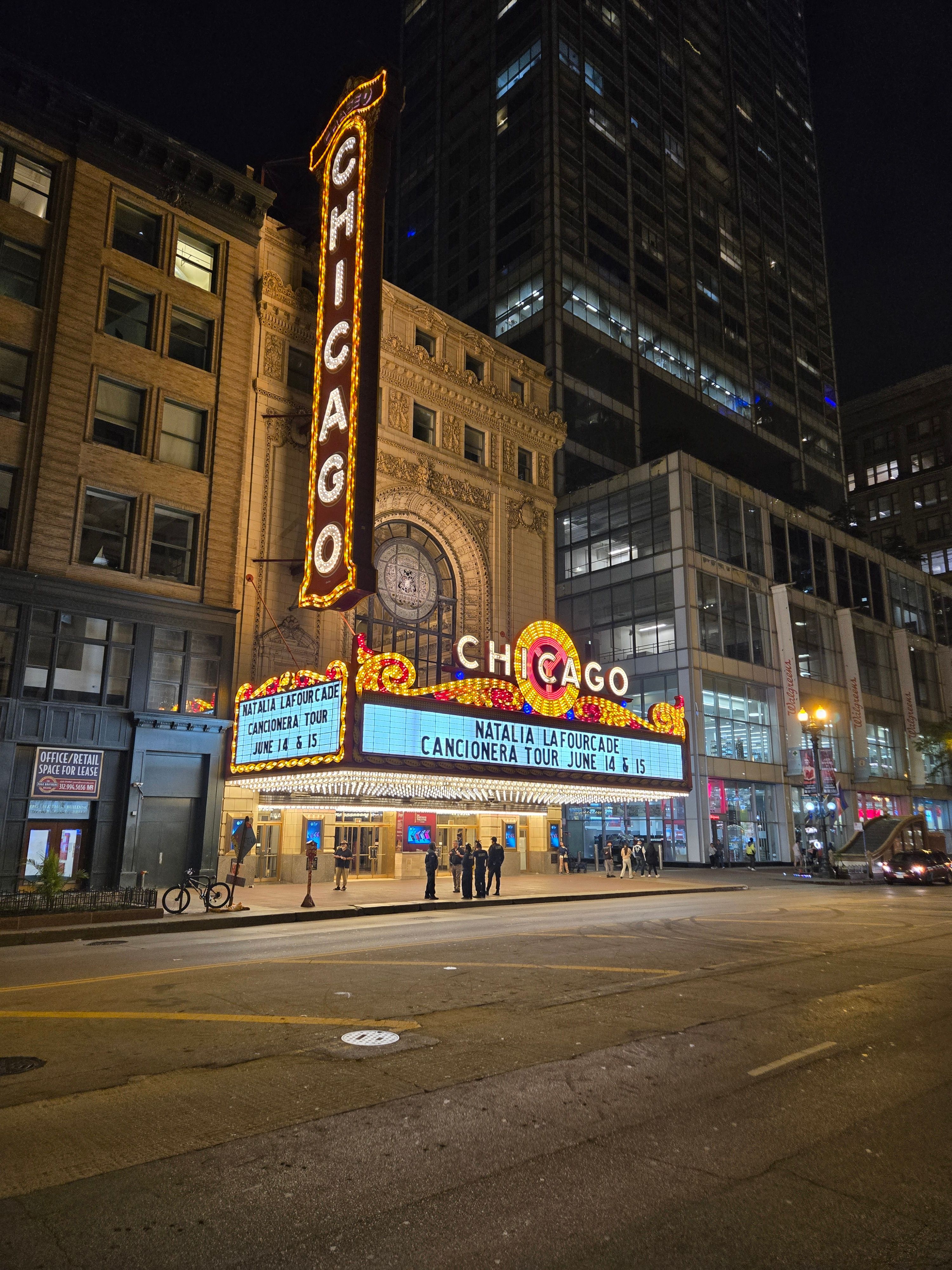 The glowing Chicago Theater marquee at night with city street view.
