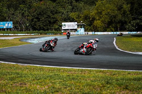 Free Thrilling motorcycle race on a track in Angeles, Philippines. Riders speed around sharp turns, showcasing skill and adrenaline. Stock Photo