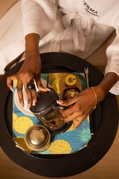 Overhead view of a woman in Abuja preparing coffee with a French press. Elegant and serene atmosphere.