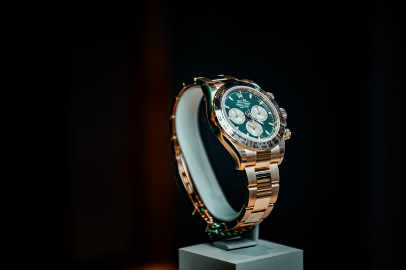 Stunning emerald green and gold luxury watch displayed elegantly against a dark background.