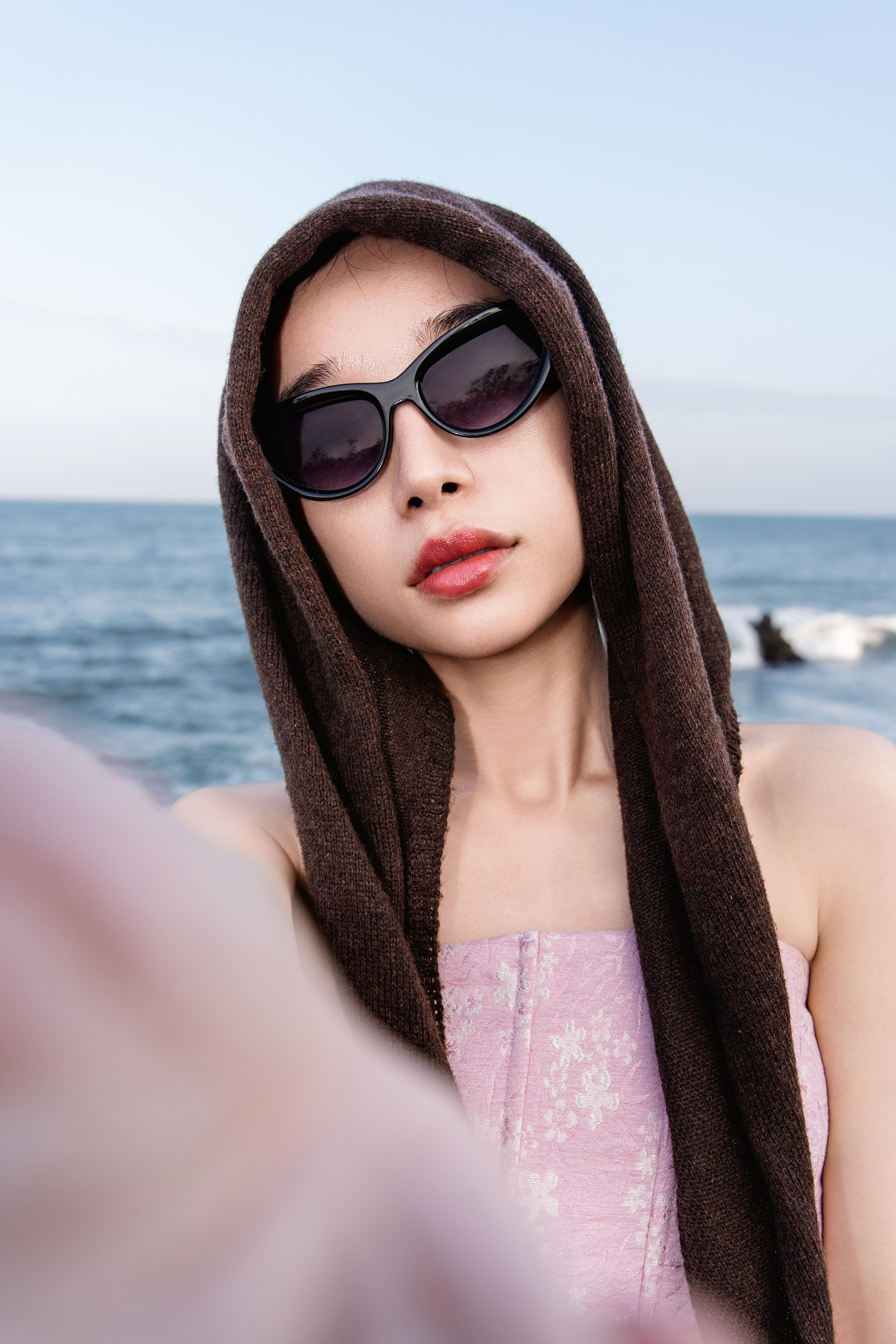 De franc Dona posant amb ulleres de sol i tovallola vora el mar a Quảng Ngãi, Vietnam. Foto d'estoc