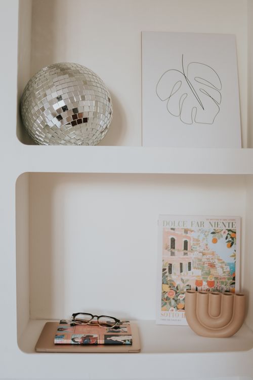 Free Stylish shelf with a disco ball, minimalist art, and chic decor in a modern setting. Stock Photo