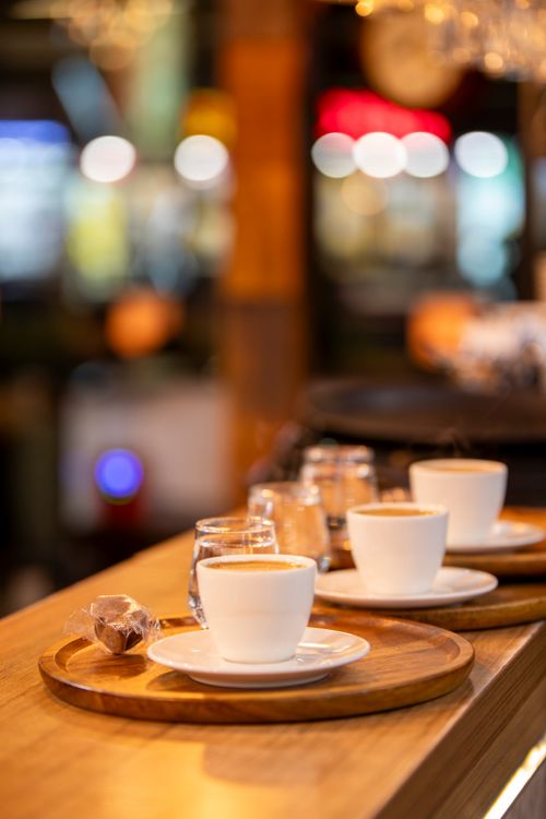 Free Warm and inviting cafe scene with steaming coffee cups on wooden trays. Stock Photo