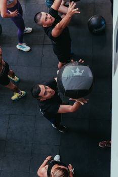 Overhead view of diverse adults in a dynamic fitness class using medicine balls