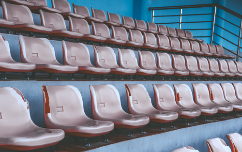 Free An array of empty plastic stadium seats in a geometric pattern, showcasing vibrant blue ambiance. Stock Photo