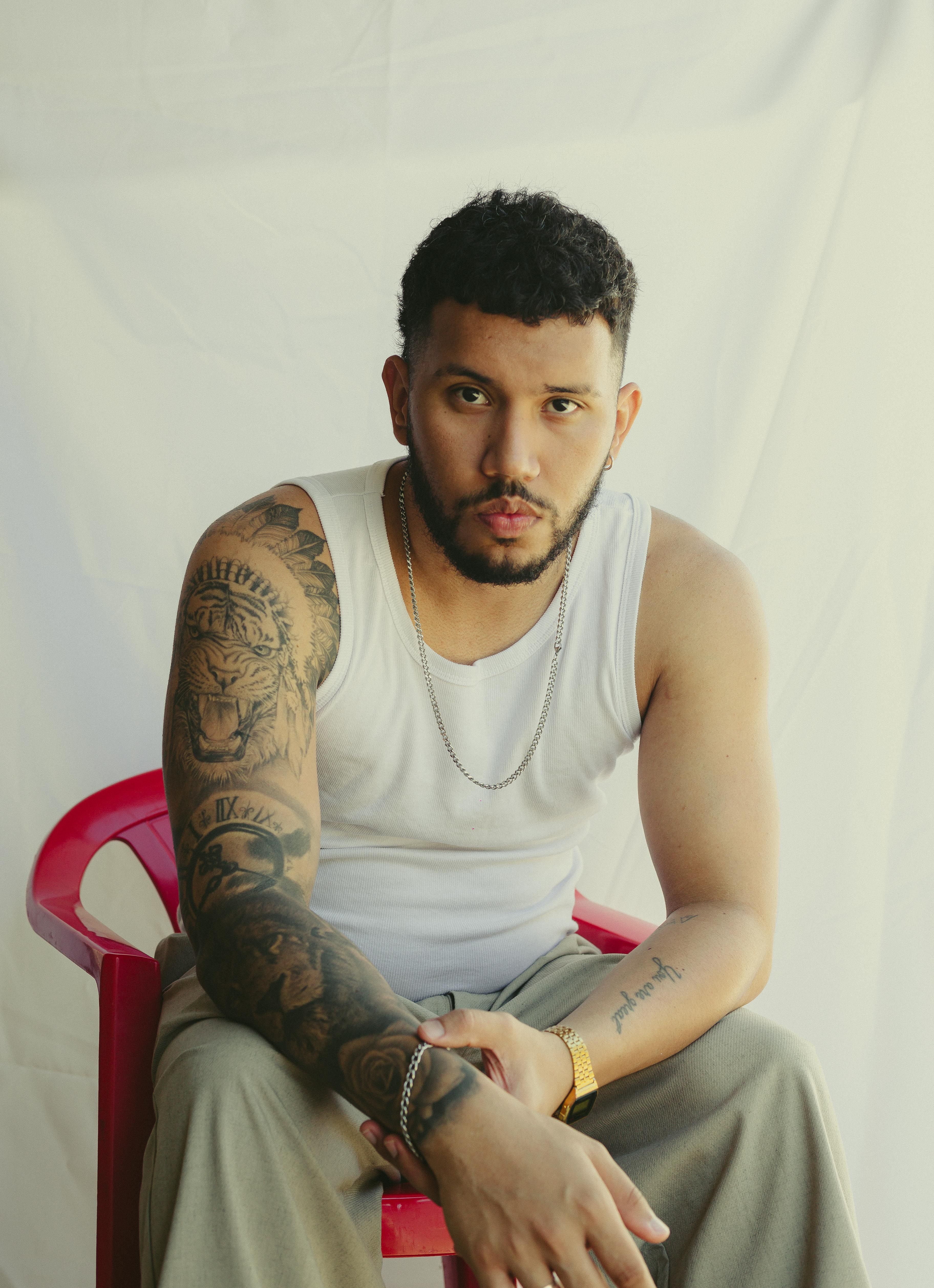 Stylish portrait of a tattooed man in a white tank top in São Paulo.