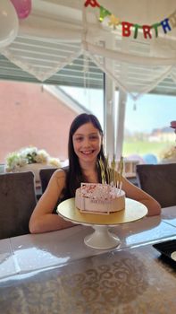 Young girl celebrating birthday with cake and decorations.