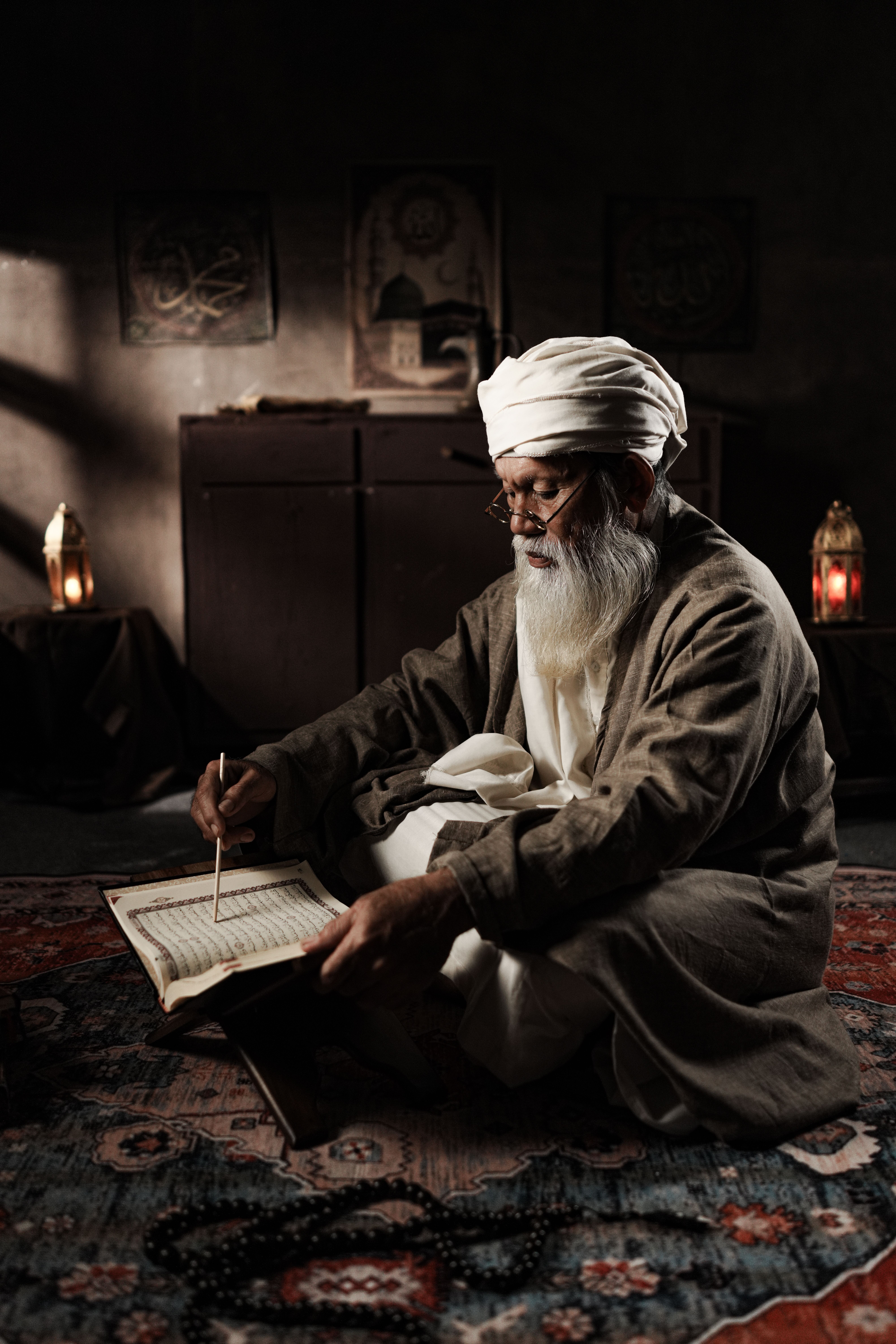 Elderly man reading religious text in dim lighting · Free Stock Photo