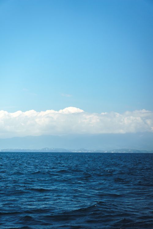 Free Serene ocean with blue sky and clouds, depicting tranquility and freedom. Stock Photo