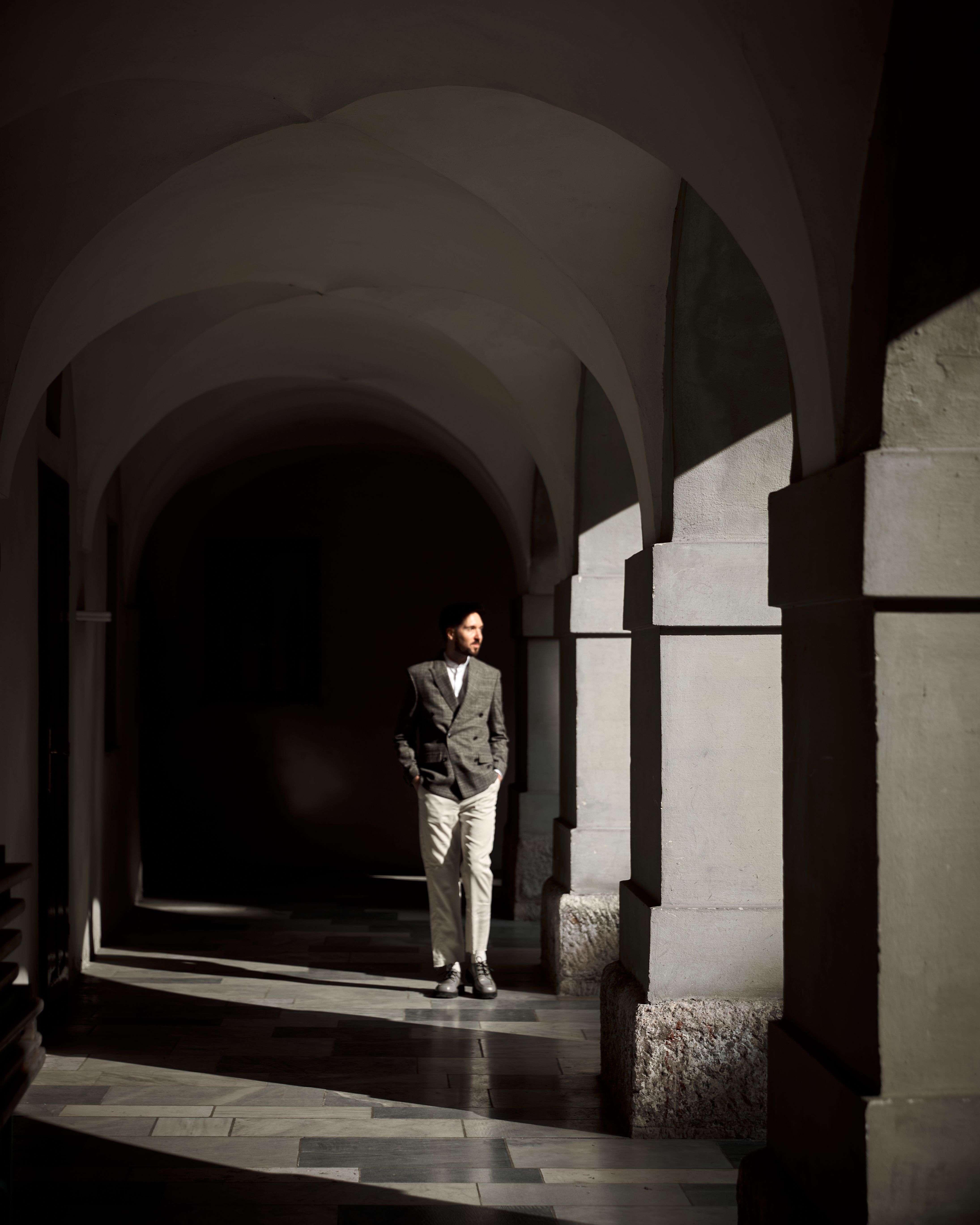 Elegant man standing in historic archway · Free Stock Photo