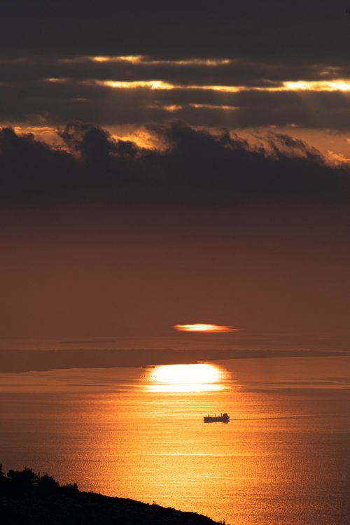 Dramatic Sunset Over Ocean with Ship Silhouette · Free Stock Photo