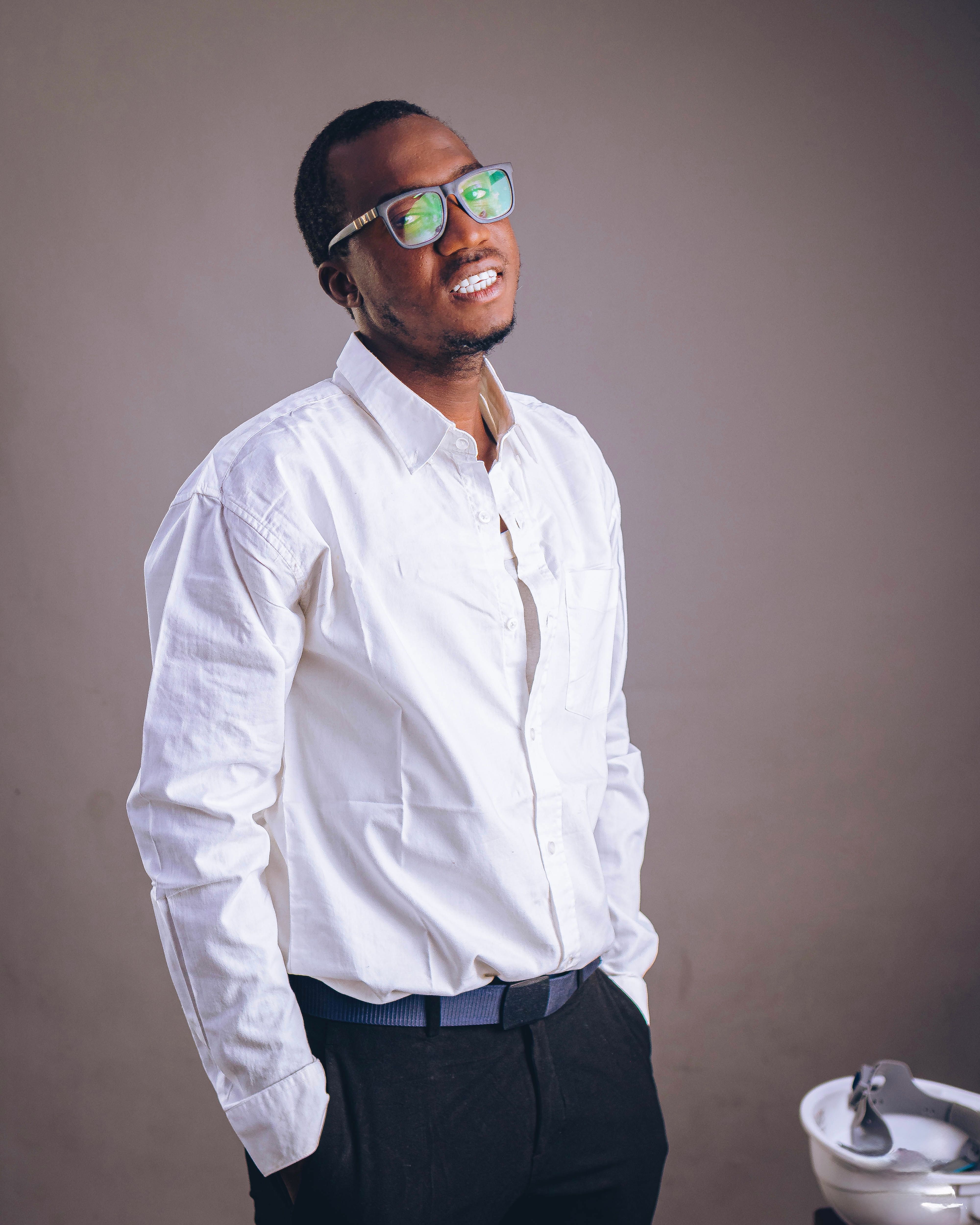 Portrait of a confident man in a white shirt and glasses indoors.