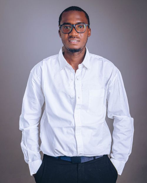 Free Portrait of a confident young man wearing a white shirt and glasses, standing against a neutral background. Stock Photo