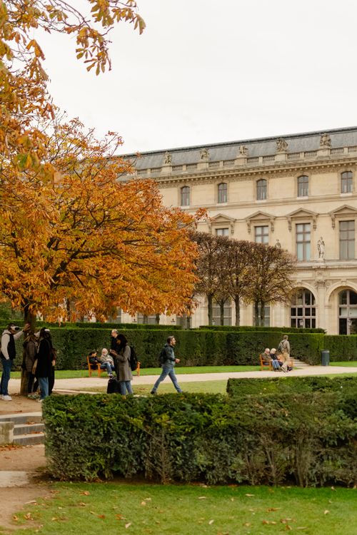 Free People enjoying a walk outside The Louvre Museum in Paris during fall. Stock Photo
