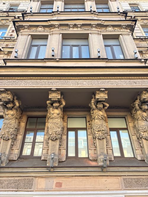 Free Ornate facade in St. Petersburg featuring classical atlantes sculptures holding up the balcony. Stock Photo