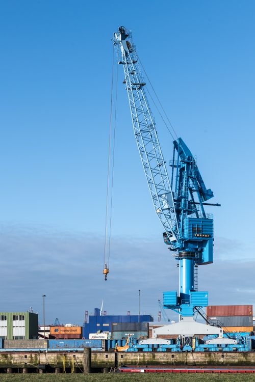Free Blue crane at Hamburg port against a clear blue sky, showcasing global commerce. Stock Photo