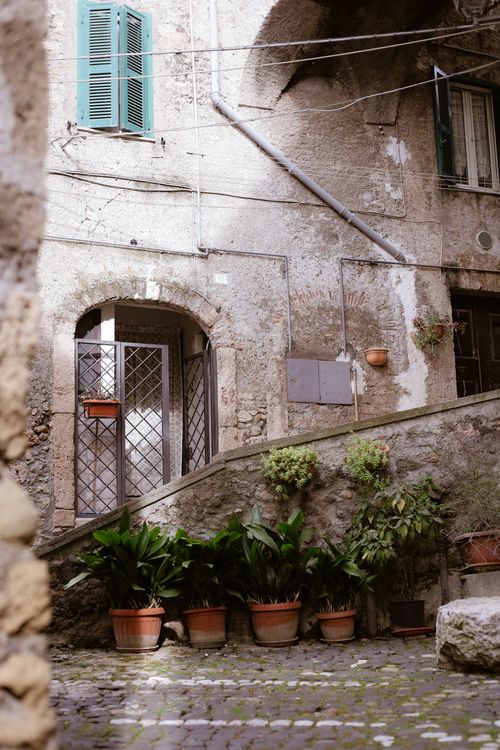 Free Rustic courtyard with plants in Anagni, Lazio, showcasing historic architecture. Stock Photo
