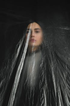 一幅描绘塑料布后女性的艺术肖像，强调了环境问题