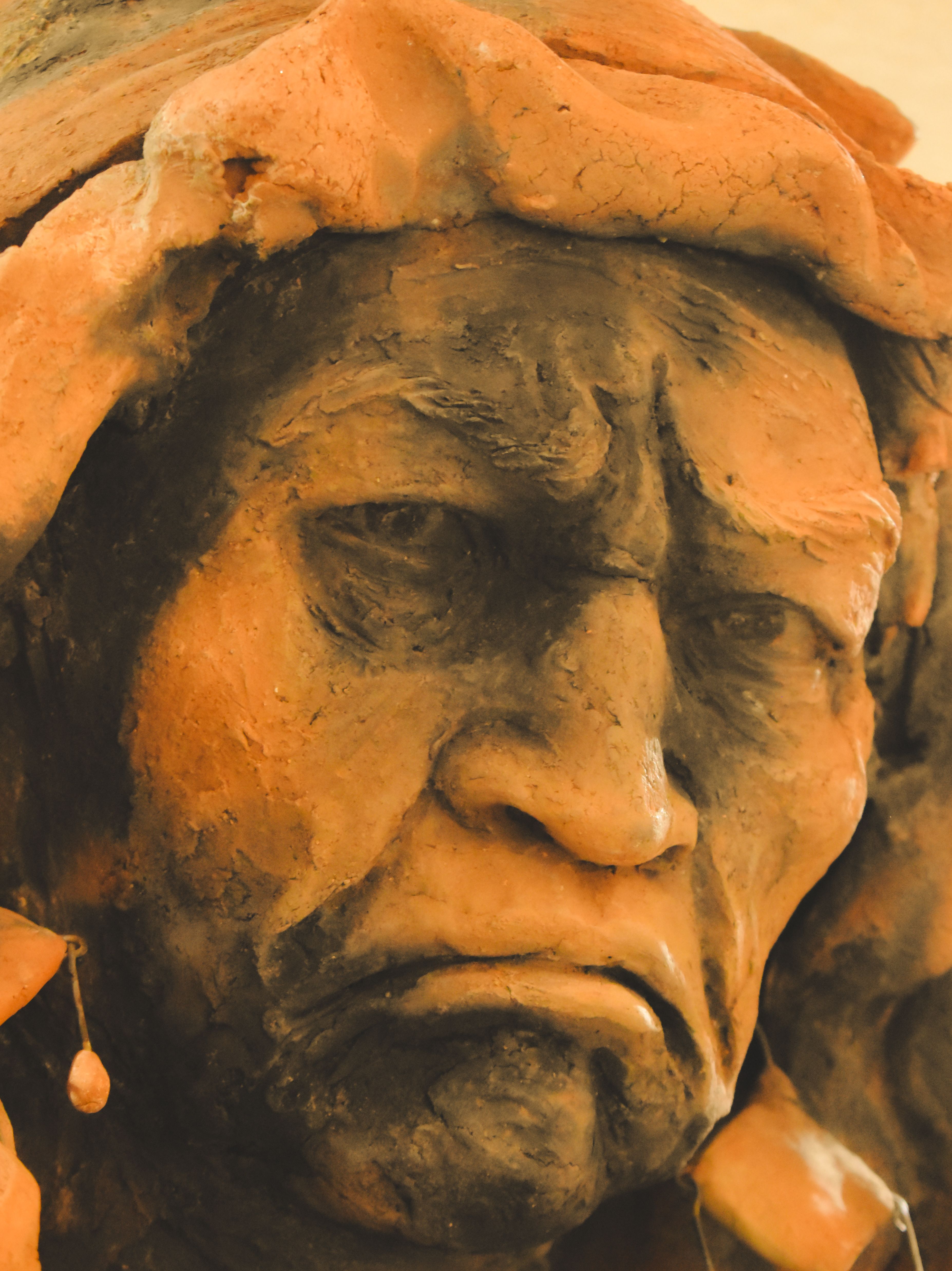 Close-up view of a detailed clay sculpture depicting an indigenous elder from Metepec, Mexico.