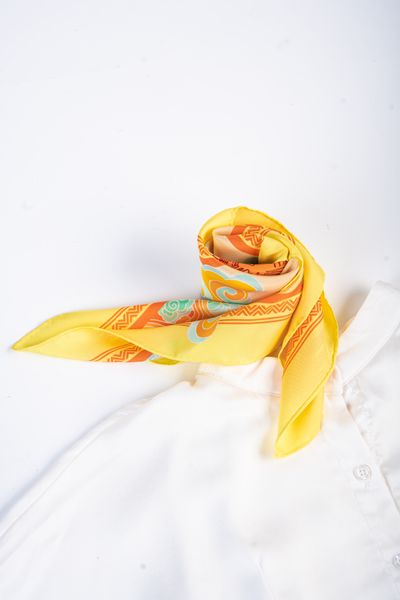 Patterned silk scarf knotted over a white shirt, photo by Dau Photograph on Pexels