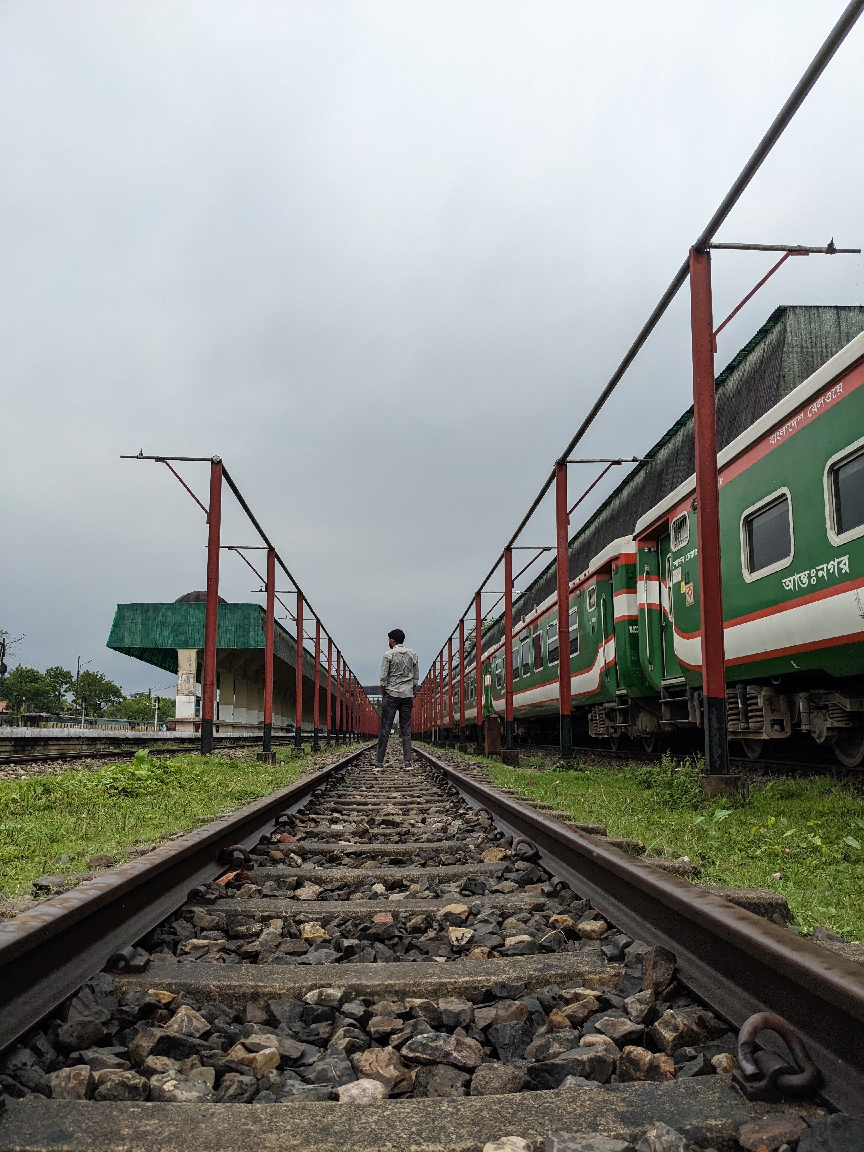 Man Standing Near Train on Railway Tracks · Free Stock Photo