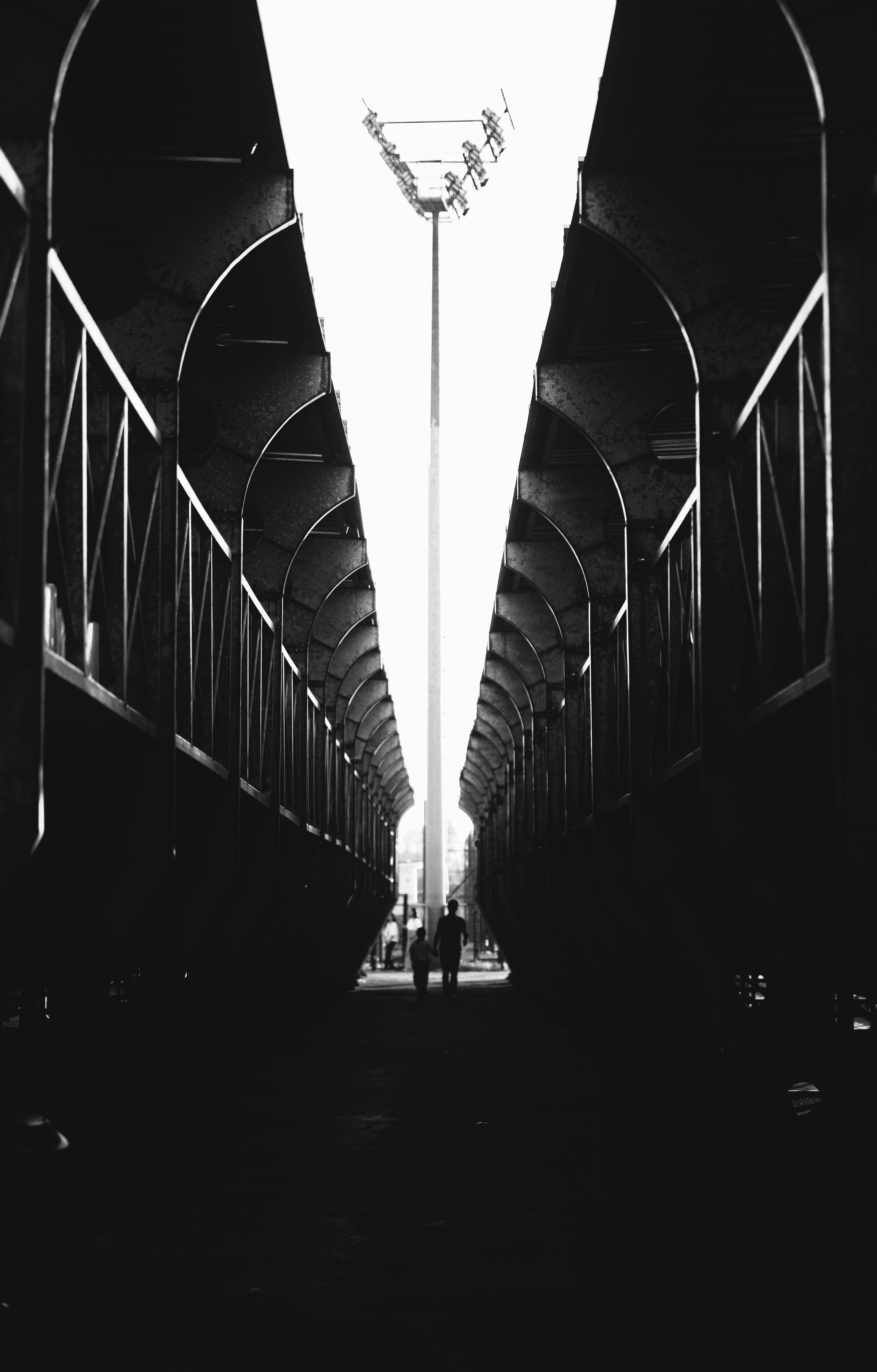 無料 トンネル効果を生み出す列車の車両の間を歩く 2 人の白黒画像。 写真素材