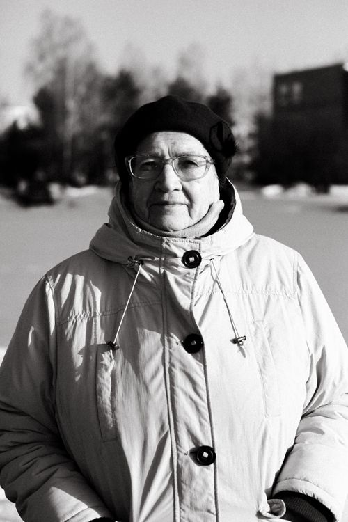 Free Black and white portrait of an elderly woman in a winter coat outdoors. Stock Photo
