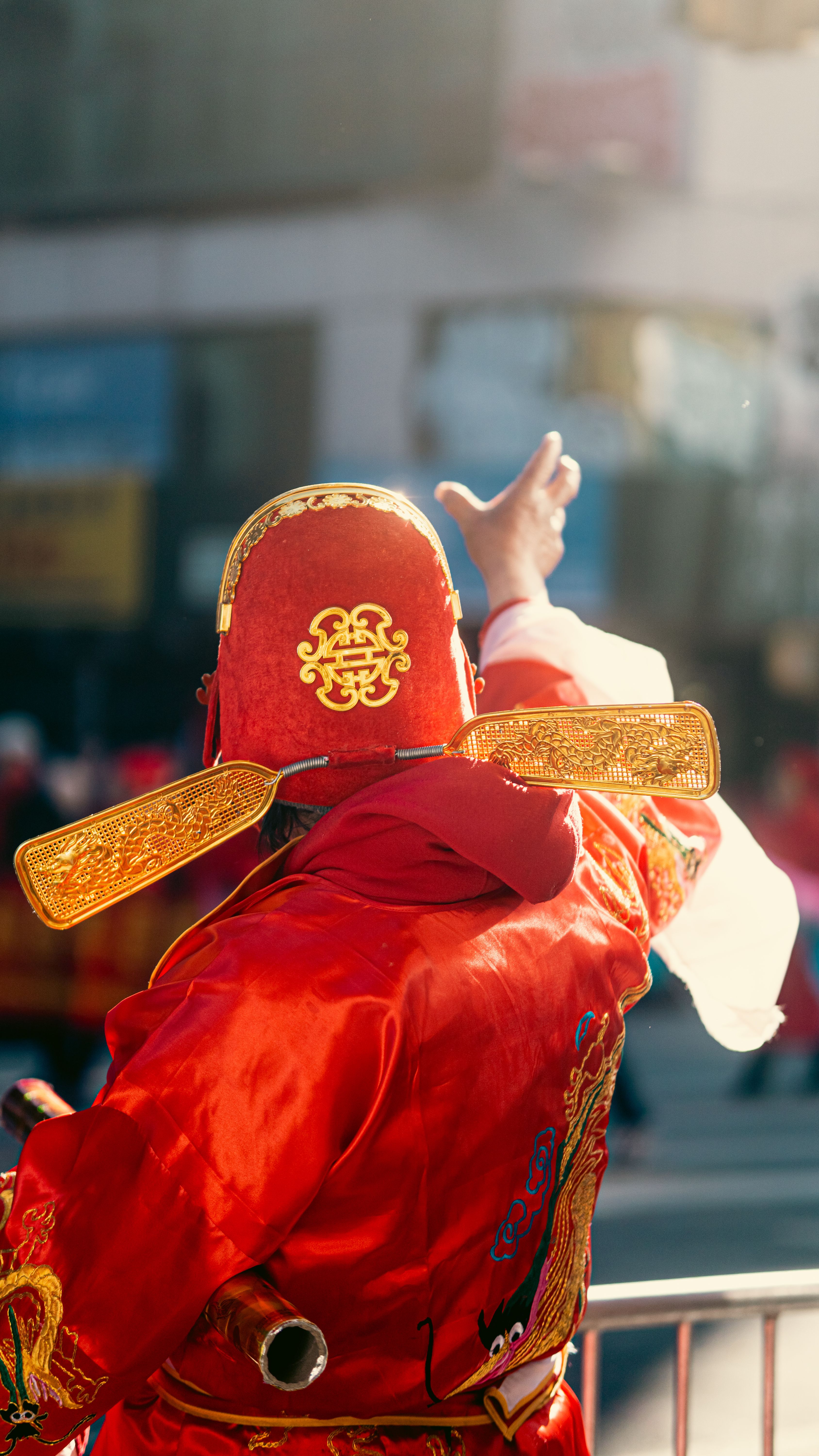 Vibrant scene of a person in traditional attire during a Chinese New Year parade in New York City.
