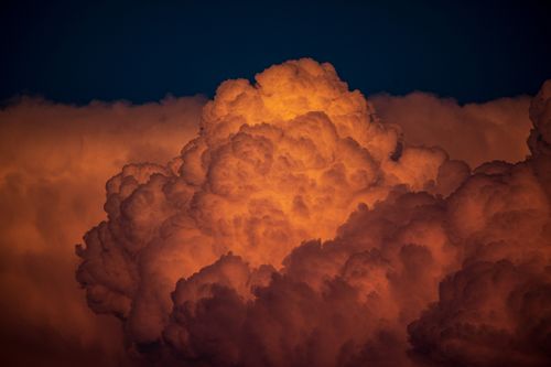 Free Majestic orange cumulus clouds captured in the evening sky, offering a dramatic visual spectacle. Stock Photo