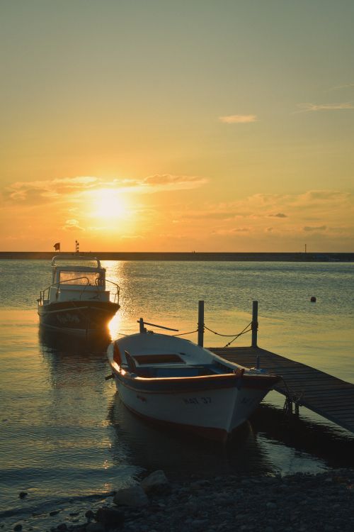Free Enchanting sunset view of boats by a jetty in Cide, Türkiye, with vibrant sky reflections. Stock Photo