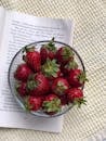 Bowl of Fresh Strawberries on Open Book