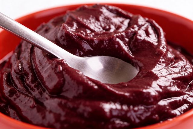 Close-up of a rich and creamy açaí bowl served with a silver spoon, perfect for a healthy snack.